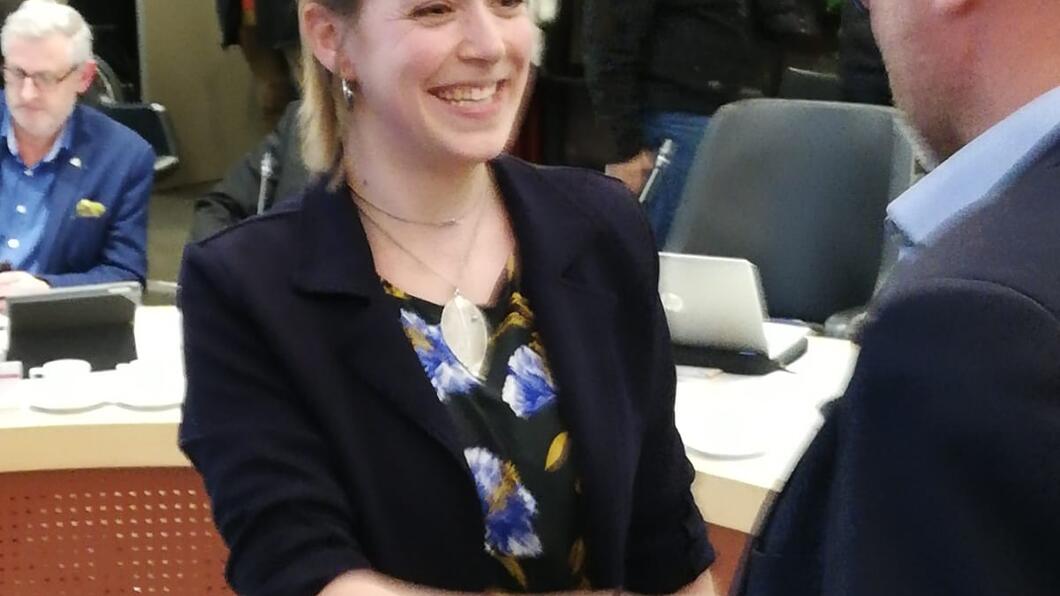 Vera wordt gefeliciteerd door de aanwezigen in de raadszaal